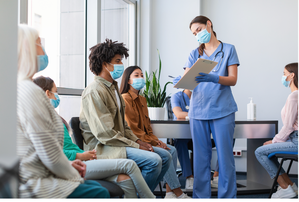 A nurse checking patients in using a clipboard