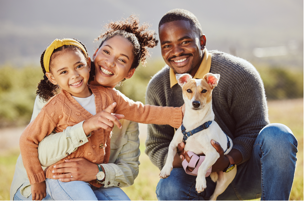 Family photo outside with their dog in a field
